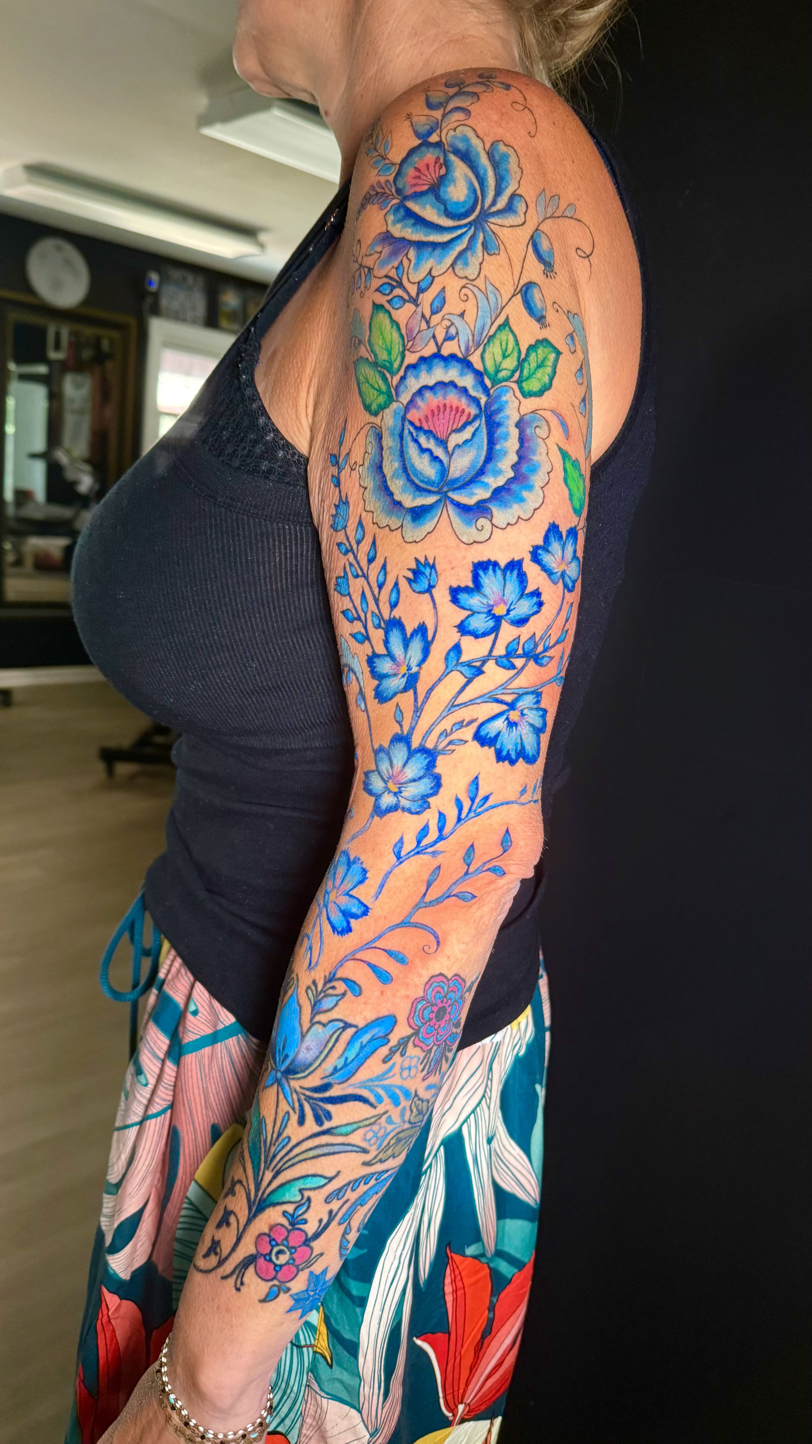 Vibrant blue folk art floral full sleeve tattoo on arm by Fata Morgana