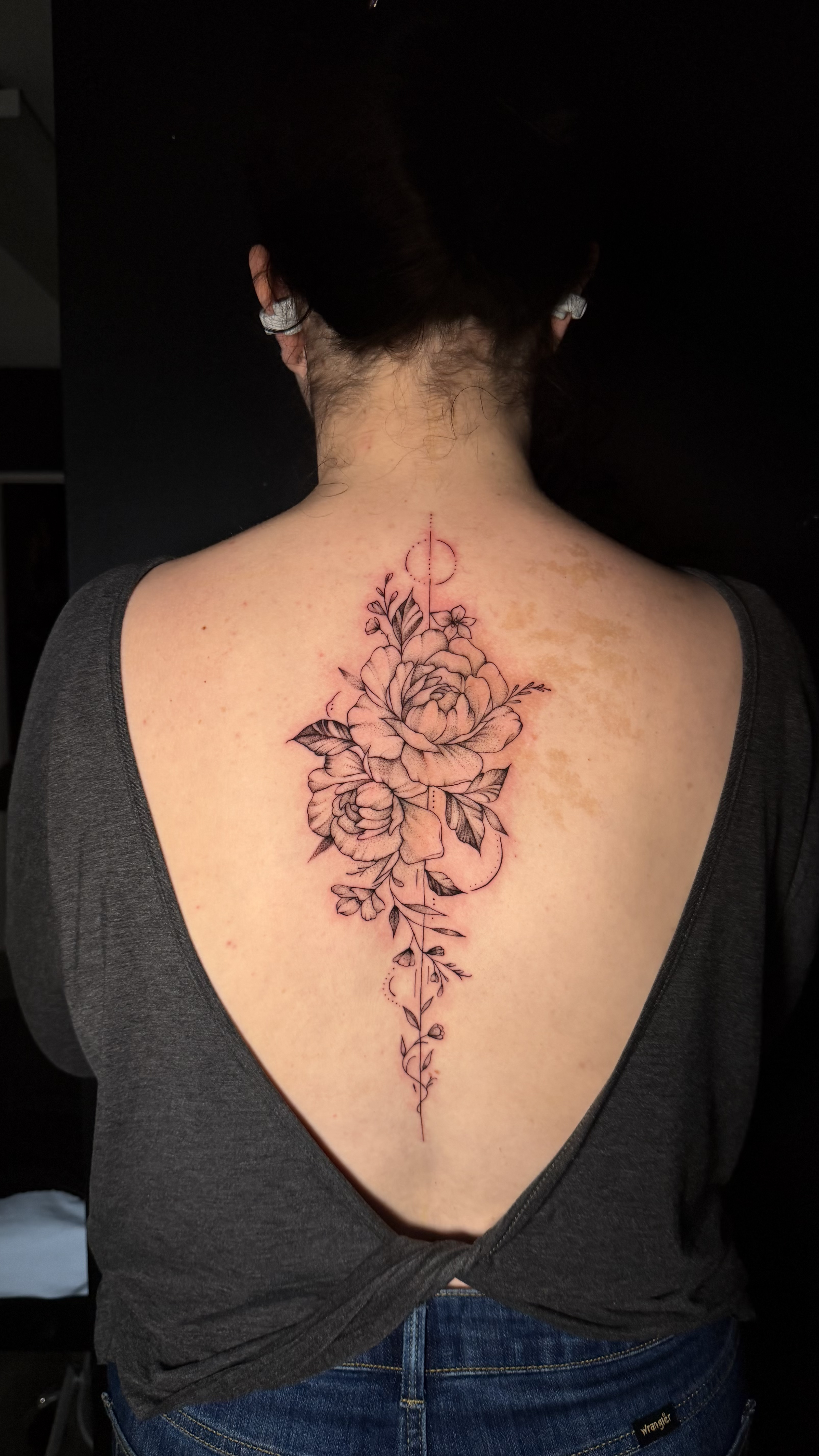 Fine line floral bouquet tattoo with script text on inner forearm